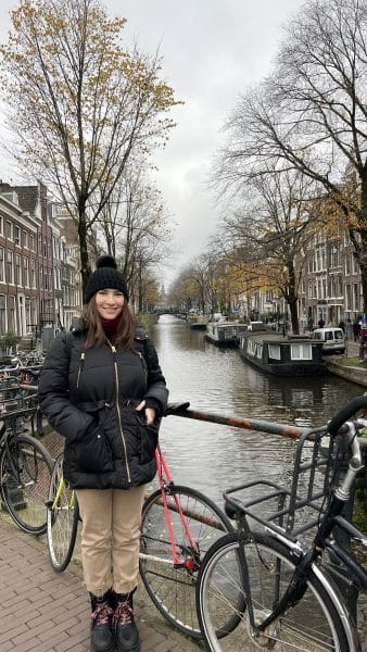 Jessica Lampner stands by bicycles and a canal.
