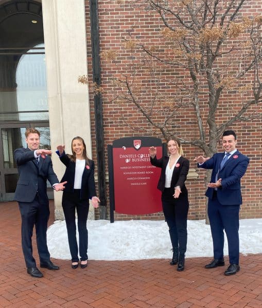 UF MBA students do the gator chomp in front of Daniels College of Business.