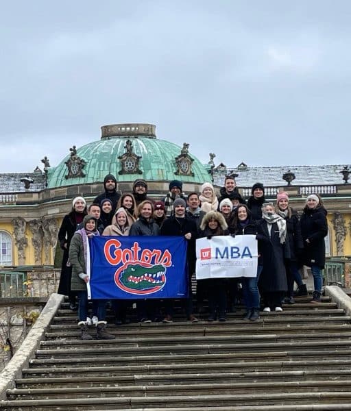 UF MBA students pose with Gator and MBA banners.