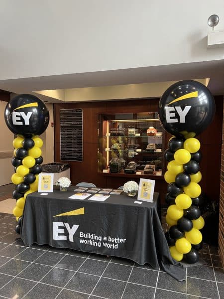 EY table in Gerson Hall with an EY tablecloth, brochures and balloons