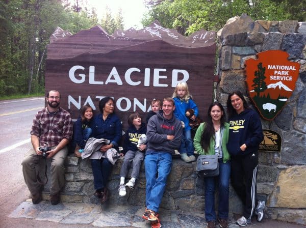 Dr. John Banko with family and friends in front of Glacier National Park sign.
