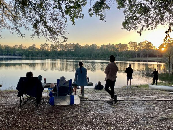 Students by the lake at sunset.