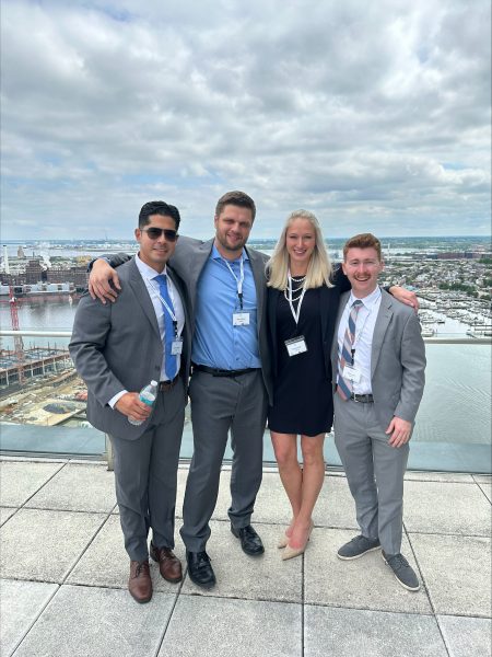 Four team members pose above the city skyline.