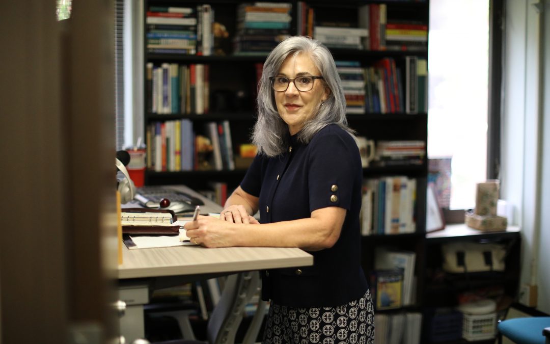 Judy Callahan stands at her desk.