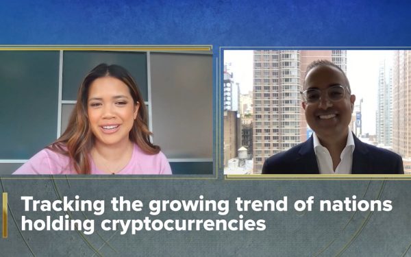 Two people talking via Zoom with text below their video screens that reads, Tracking the growing trend of nations holding cryptocurrencies.