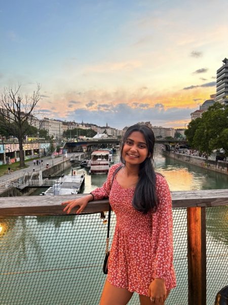Grishma Patel poses over a river at sunset.