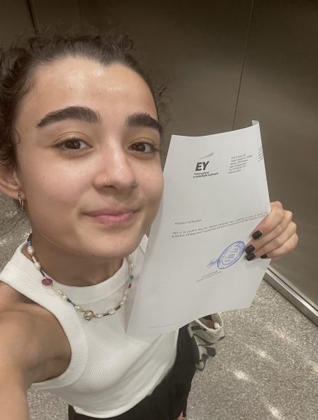 Mariam Sargsyan holds a piece of paper next to her face.