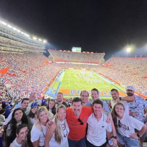 Students pose in a football stadium.