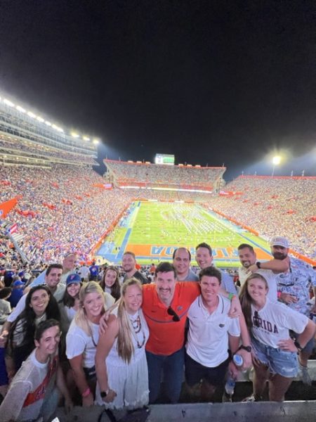 Students pose in a football stadium.