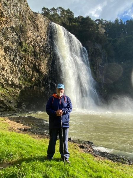 Robert Knechel standing in front of a waterfall.