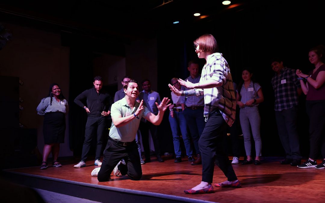 Students on stage during a business improv performance.