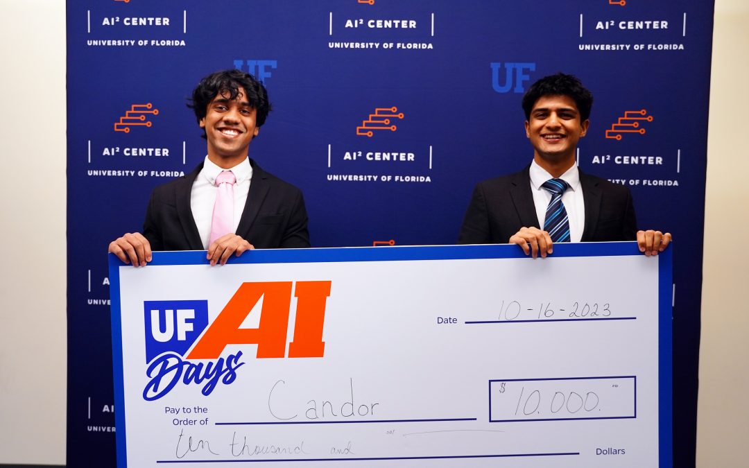 Two students hold a $10,000 prize check.