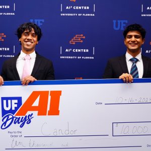 Two students hold a $10,000 prize check.