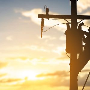 silhouette engineer working maintenance transformer on pole elec