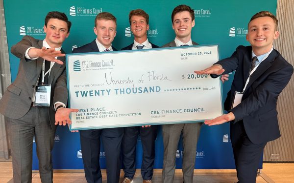 Five students hold a large check for $20,000.