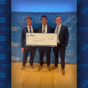 Three students hold a $500 prize check.