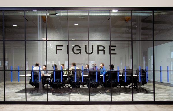 Figure employees sit under the company logo at a conference table.