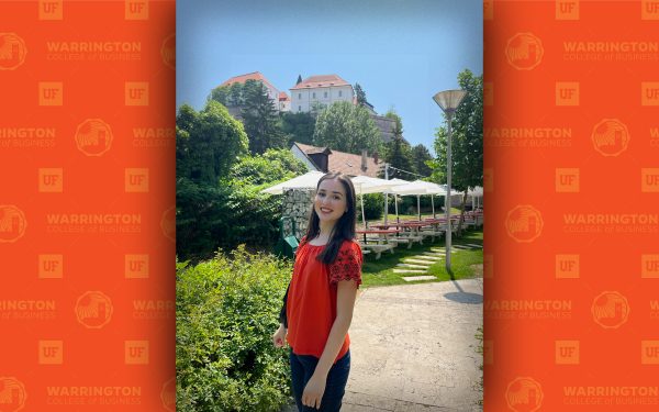 Reka Holicsek in an orange shirt standing in a garden.