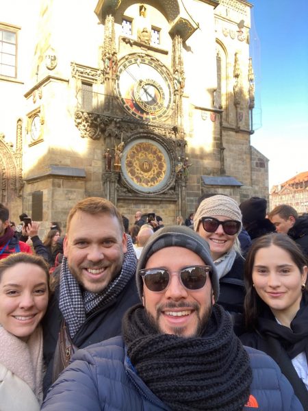 Students pose in front of Prague's historic astronomical clock.