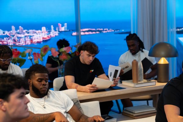 Students study information packets above Miami skyline.