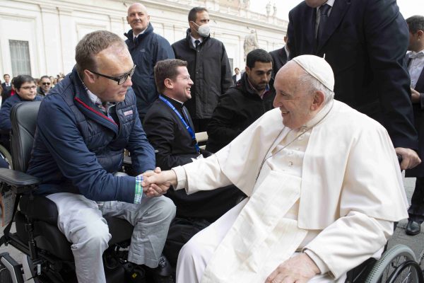John Morris shakes hands with Pope Francis.