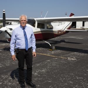 Mike Jones poses for a photo in front of his Cessna plane