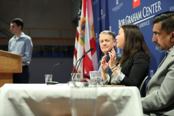 Panelists speak at a conference table.