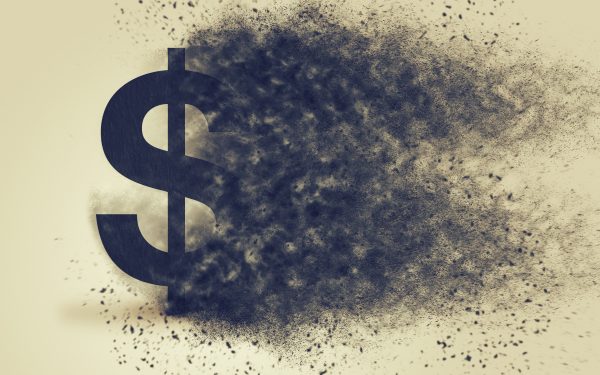 Dollar sign exploding and dissolving, concept of currency devaluation and inflation