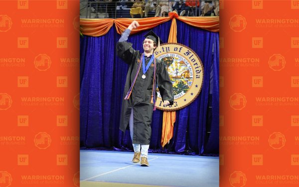 Taylor Anderson cheers in graduation robes.