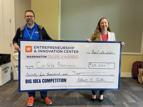Two people hold prize check of $25,000 for Cordelia Biosciences.