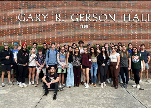 A class crowds under sign for Gary R. Gerson Hall.