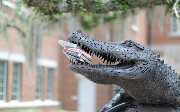 Large gator statue holds books in its open mouth