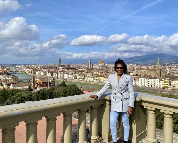 Lisa Thelwell poses for a photo in front of a cityscape in Europe.