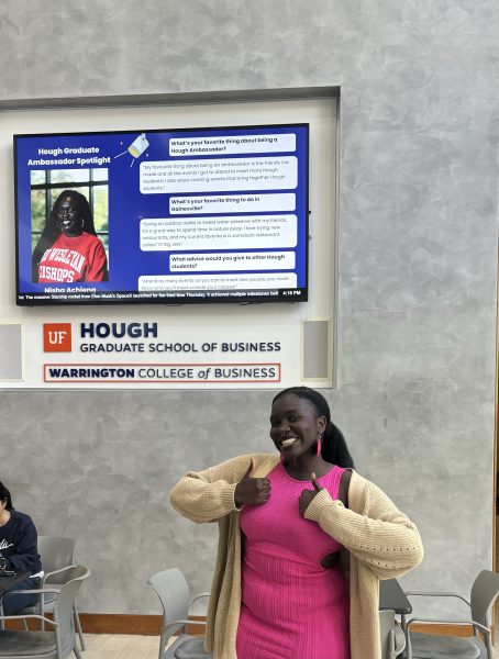 Nisha Achieng poses next to a poster about herself.