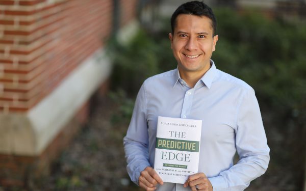 Alejandro Lopez-Lira holding his book.