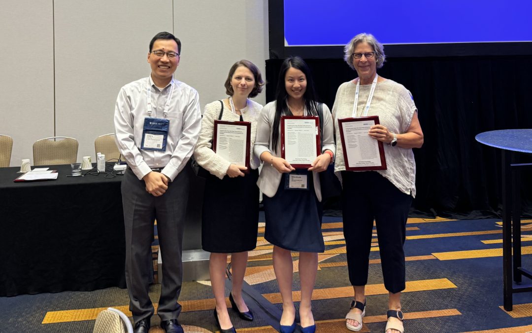 Four people, including Elisabeth Gilbert, Min-Hsuan Tu and Joyce Bono, post for a photo holding awards for their research paper.