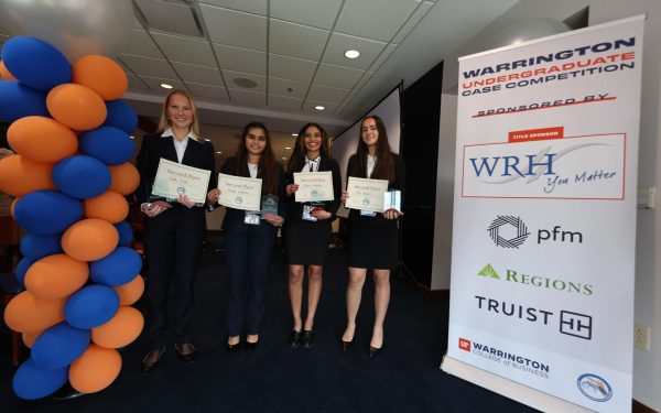 Four students holding 2nd place awards at an undergraduate case competition