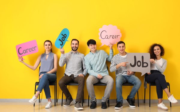 Young people holding speech bubbles with words JOB and CAREER indoors.