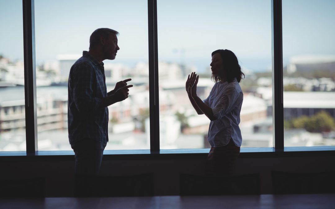 Business couple arguing near the window