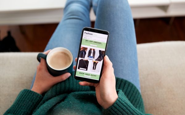 Close Up Of Woman Shopping For Clothes Online Using Mobile Phone App