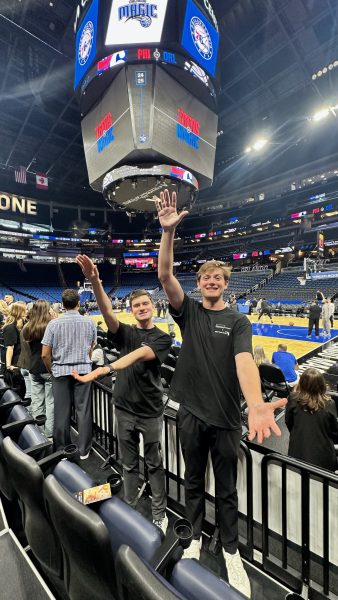 Students do the Gator Chomp in a basketball stadium.