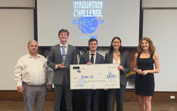 University of Florida students hold awarded first place ,000 check under a projection reading Innovation Challenge.