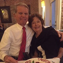 Tom Jennings and his wife sit next to each other at a restaurant.