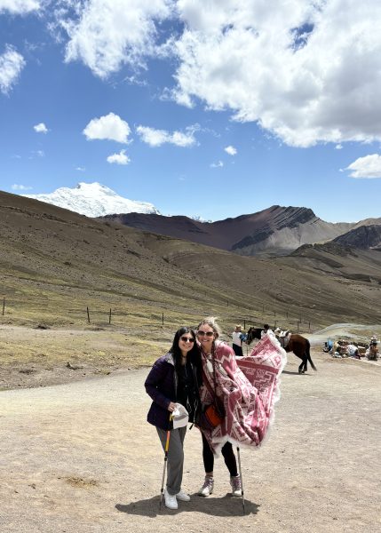 Two students pose in front of a mountain vista.