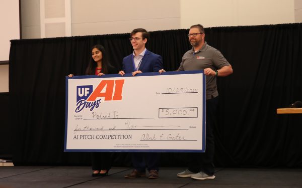 Winners Ashni Zaverchand and Alexander Simes hold their 5,000 dollar check with Jamie Kraft