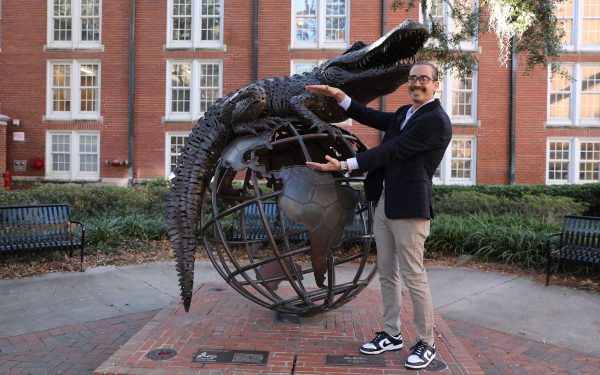 Trevor Foulk does the Gator chomp with GUS sculpture.