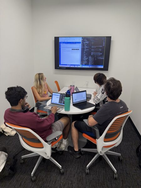 Members of the UF AI Days Pitch Competition Fall 2024 winning company PatentIt sit gathered at a table working