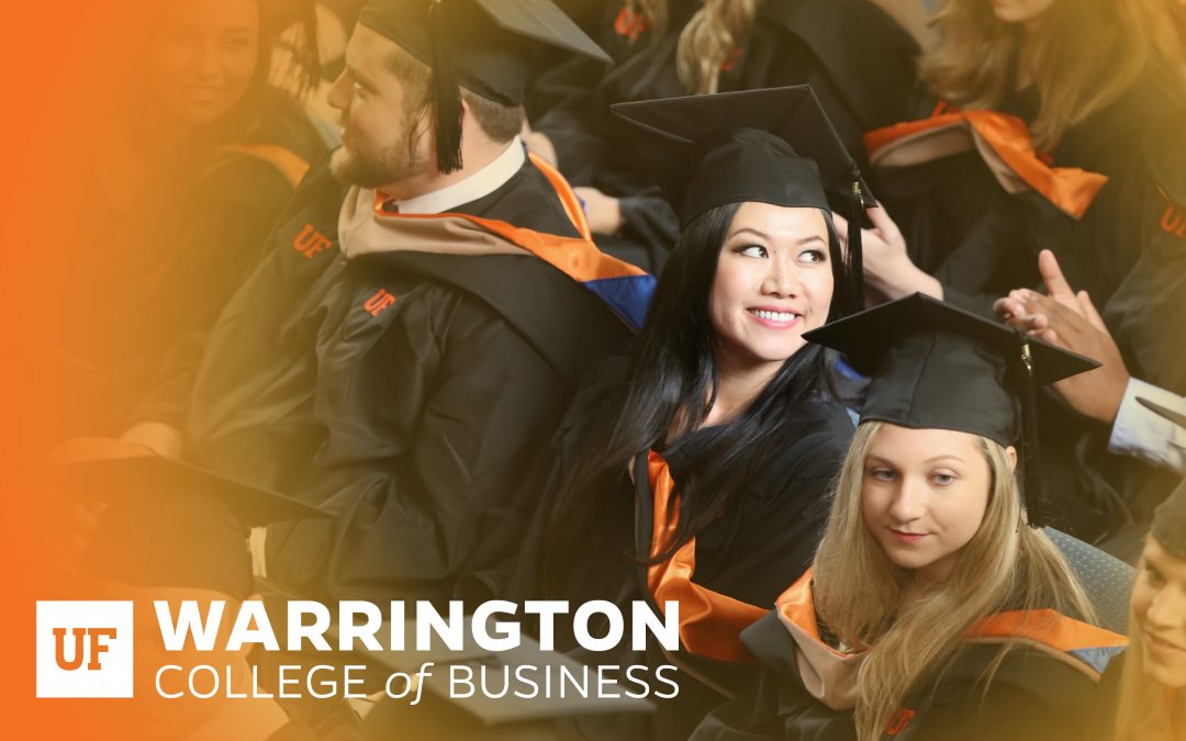 Row of graduates smiling with the Warrington College of Business logo