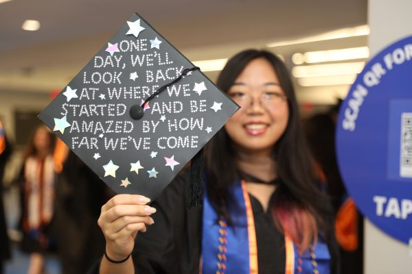 Student holds graduation cap