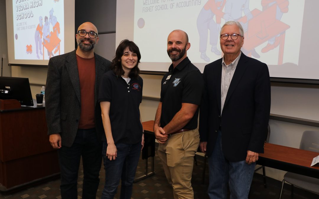 Faculty and friends pose next to a slide presentation.